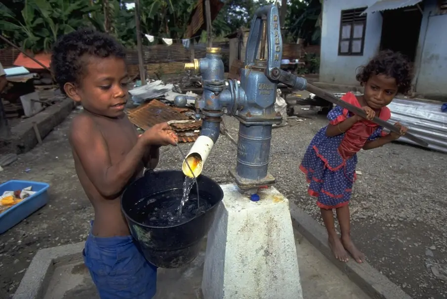 Children draw water from a hand-pump Dili, the capital of Timor-Leste.