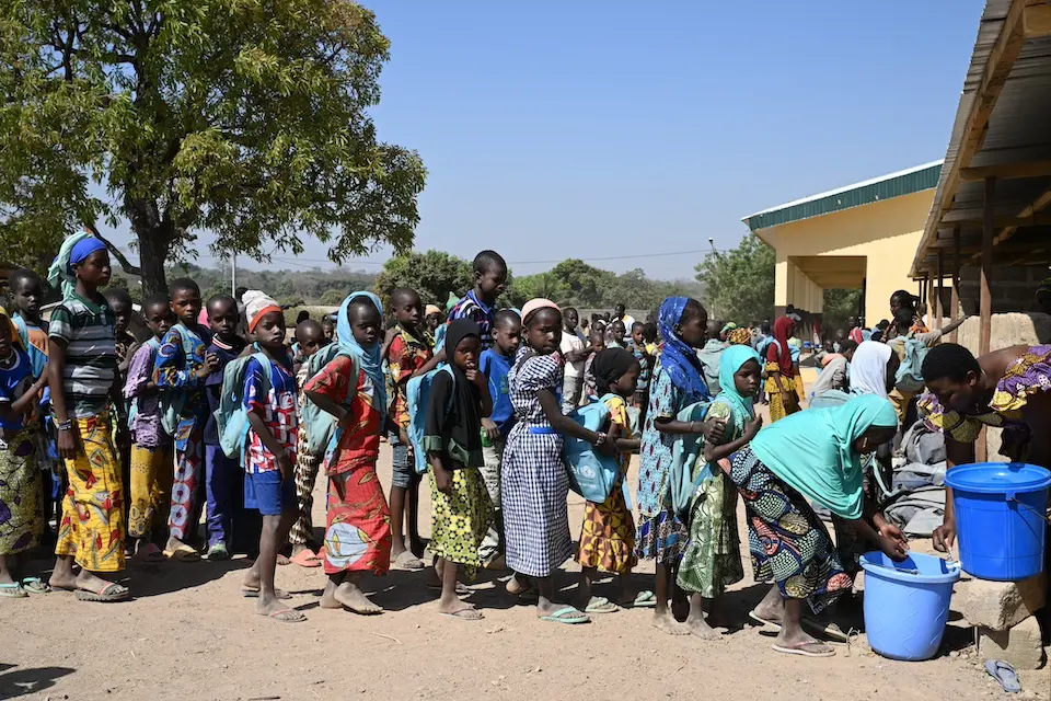 Children line up to wash their hands outside a temporary learning space in the village of Nioronigue, northern Côte d’Ivoire.
