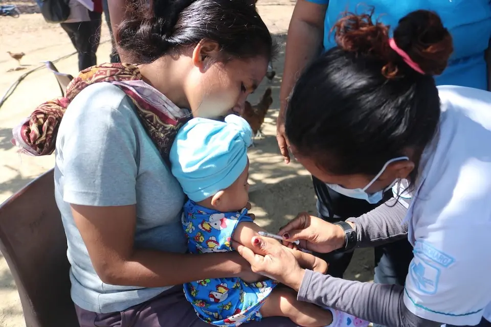 A 6-month-old baby receives vaccine shots in Timor-Leste.