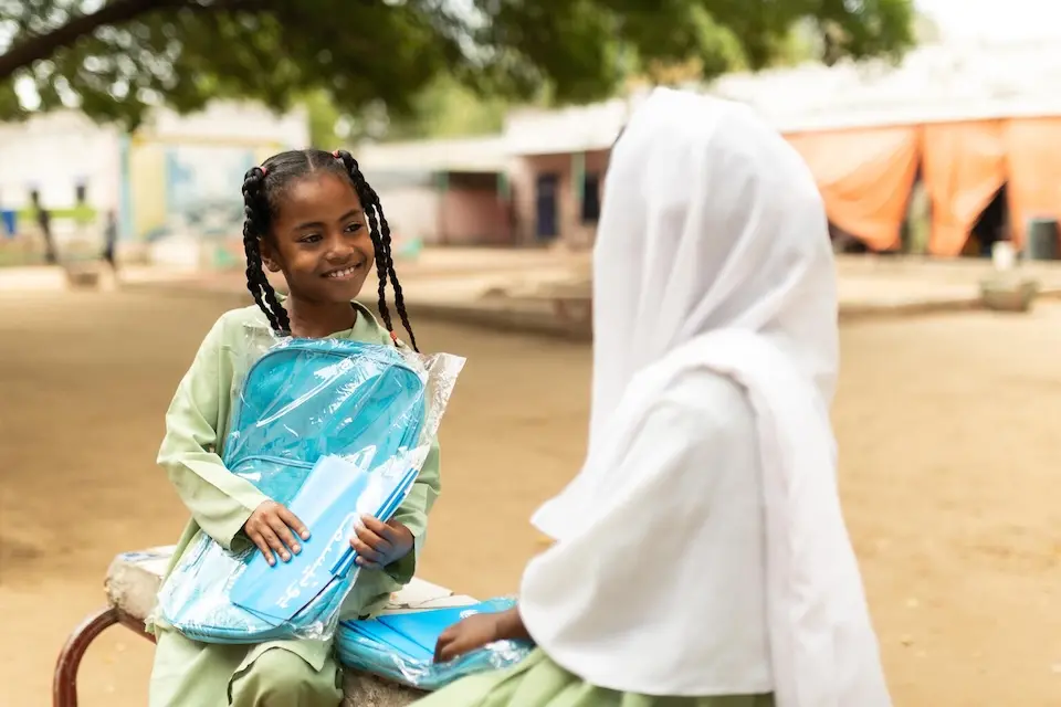 Girls hold their new UNICEF school kits at a school in Blue Nile state, Sudan.