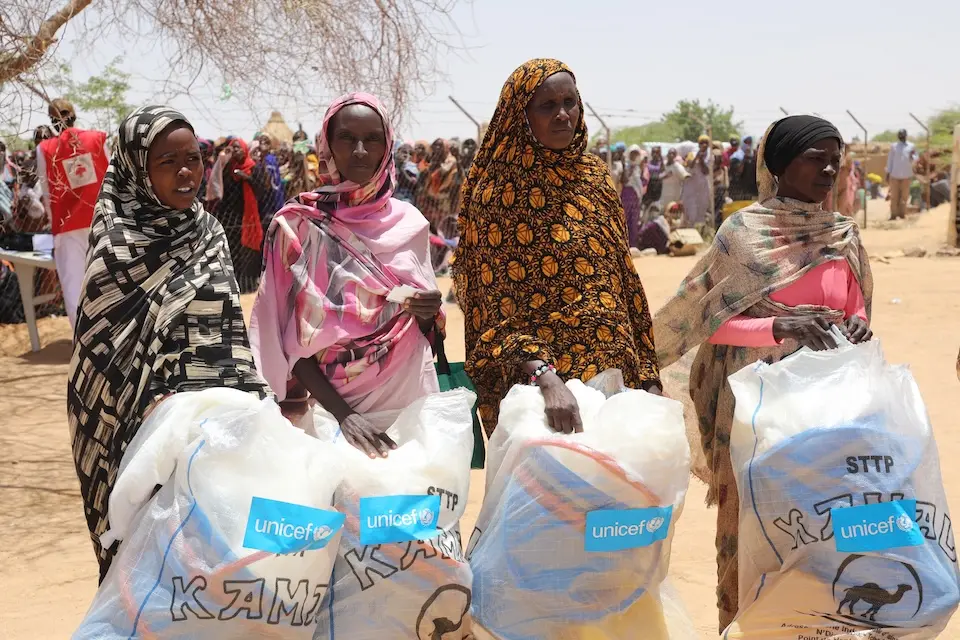 Sudanese refugees hold hygiene and sanitation kits distributed by UNICEF at a camp in Chad.