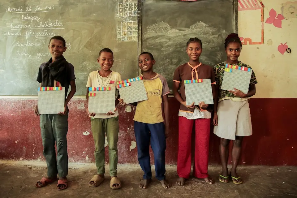 In Madagascar, students proudly present the sentences they wrote with LEGO Braille Bricks.