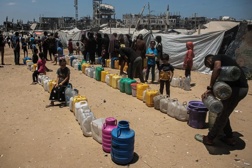 Children wait in a line at a water distribution point in Gaza City.
