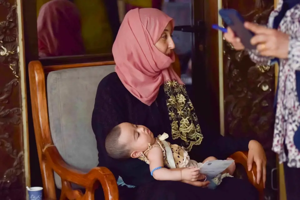 A mother holds her 5-month-old infant in her lap at a UNICEF-supported shelter in Rural Damascus, Syria.