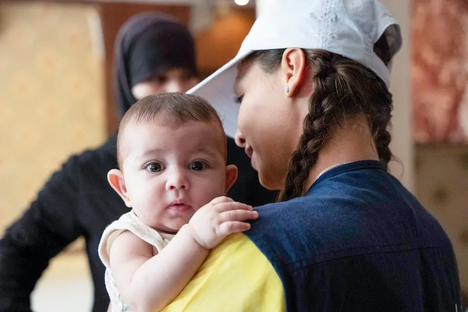 A nutrition worker from a UNICEF-supported mobile team holds 5-month-old Samar at a shelter in Syria.