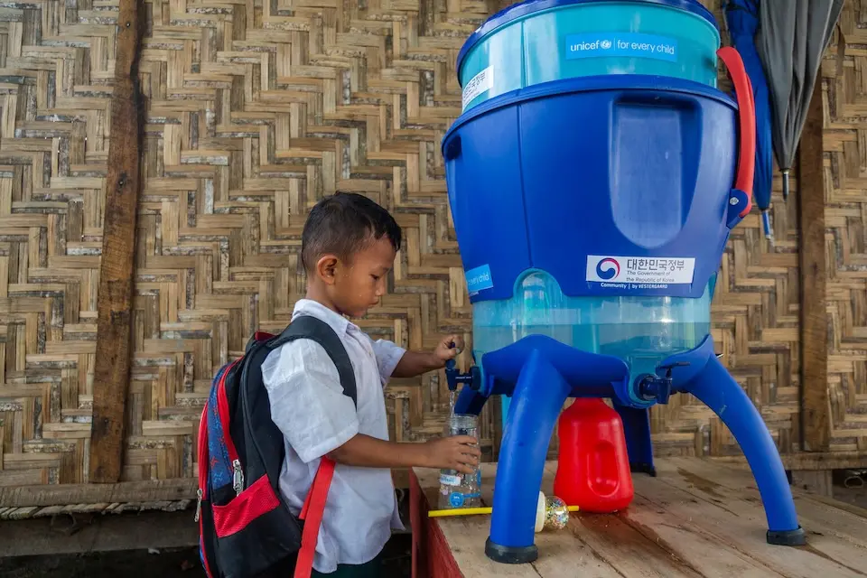 In Waing Maw Township, Myitkyina, Myanmar, a boy refills his water bottle from a water tank provided to his school by UNICEF.