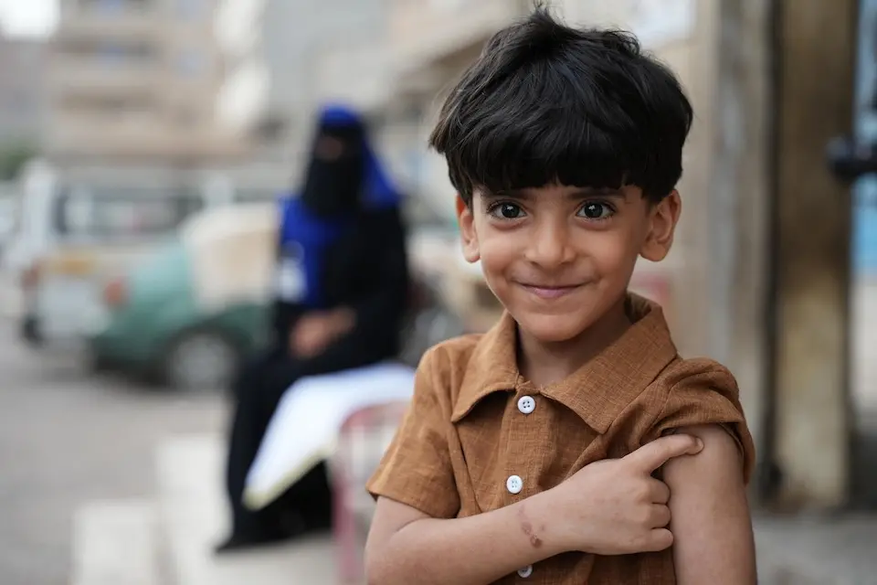 In Aden, Yemen, a smiling boy points to the place on his arm where he was vaccinated during a measles and rubella immunization campaign supported by UNICEF. 