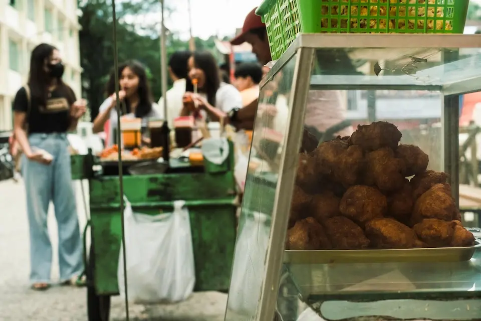 On July 6, 2023, in Catbalogan, Philippines, children buy street food at a stall outside Samar National School.