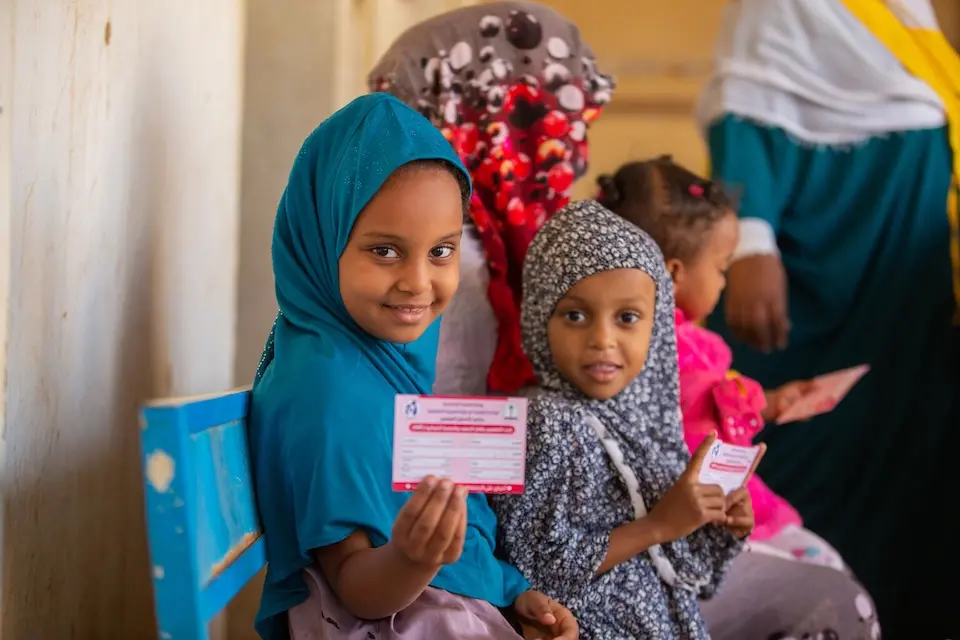 A young girl holds her vaccination card after being vaccinated against measles and rubella in Kassala state, Sudan.