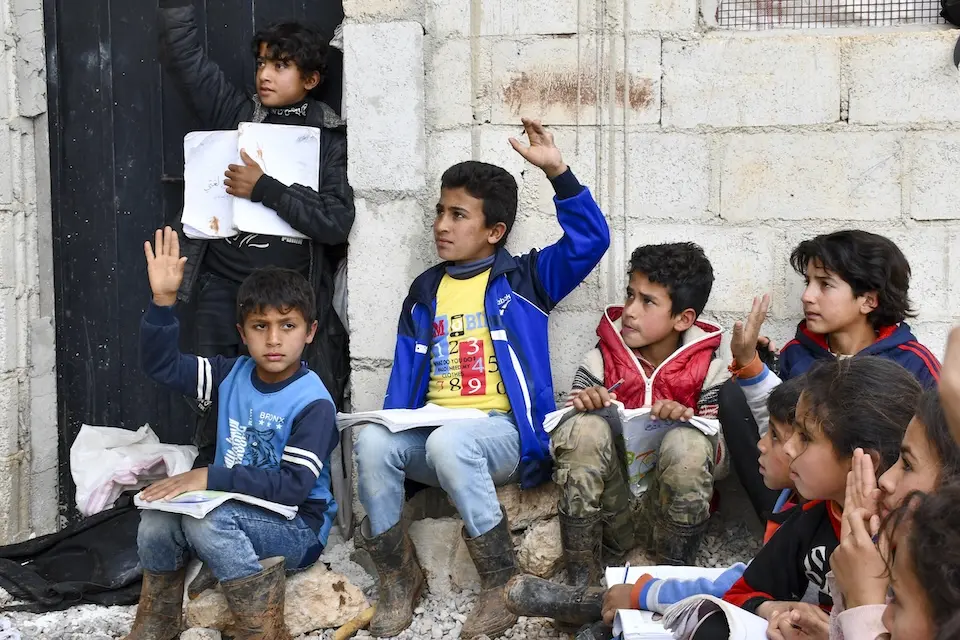 Children take part in an Arabic class delivered by a UNICEF-supported self-learning mobile team at a camp in rural Dar'a, Syria.