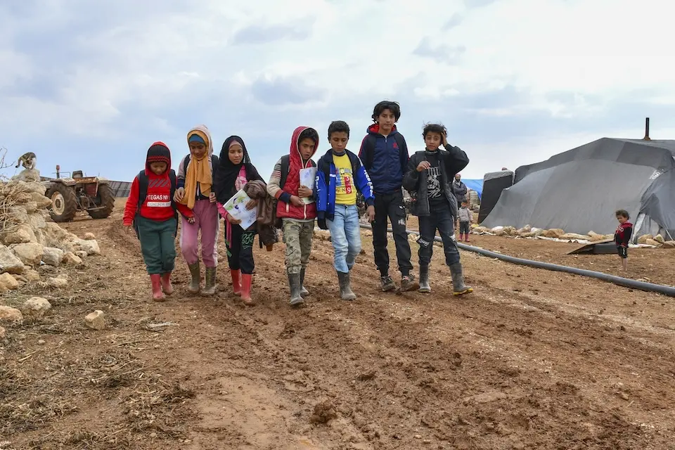 Children walk home after after attending a UNICEF-supported self-learning class in a camp for the displaced in rural Dar'a, Syria.