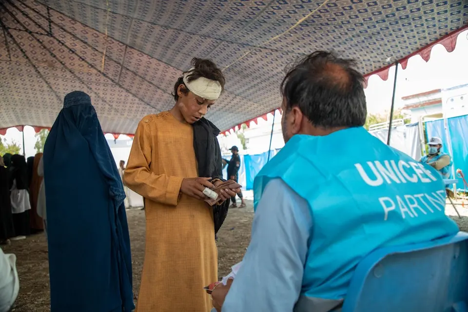 On Sept. 7, 2025, 13-year-old Khadayatullah and his mother (behind him) receive UNICEF cash assistance following a major earthquake in Noorgal district, Kunar province, eastern Afghanistan.