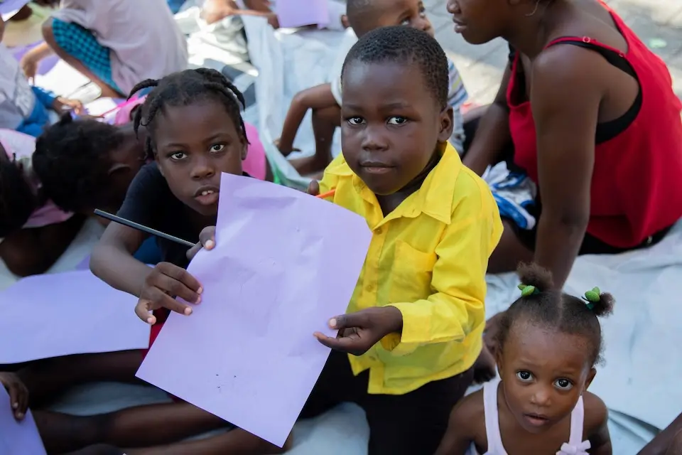 Children in Haiti show off artwork they created in a safe space provided by UNICEF amidst violence in the country
