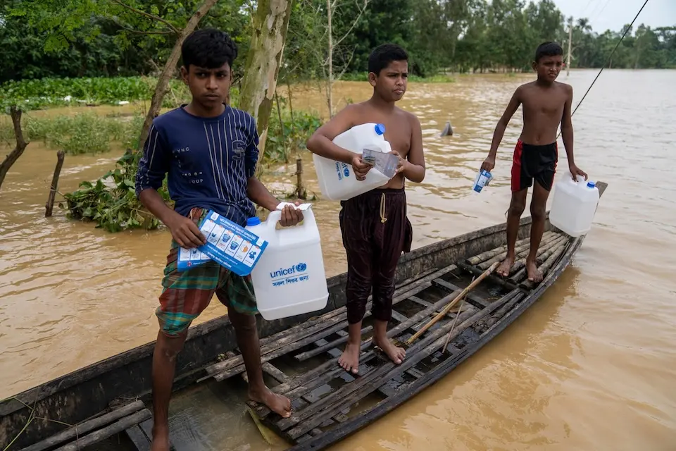 Flood-affected families in Bangladesh take home supplies provided by UNICEF