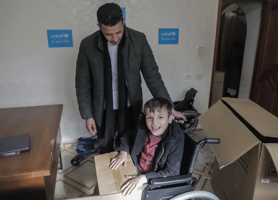 A boy in Gaza receives a wheelchair provided by UNICEF.