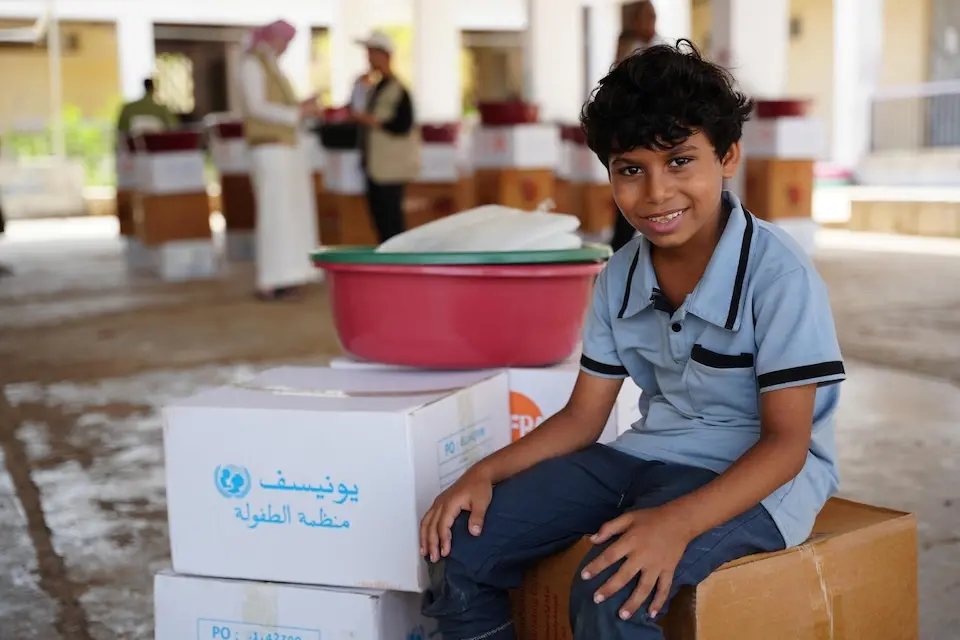 A child in Yemen sits with an emergency kit provided by UNICEF