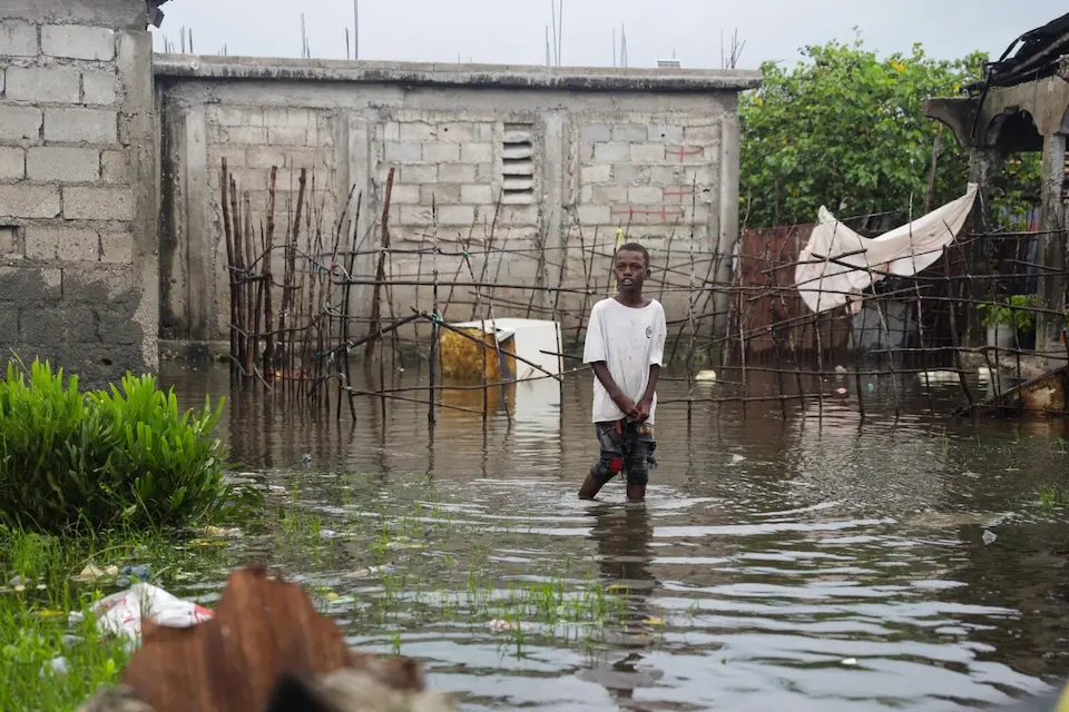 On Oct. 29, 2025, a child walks through the flooded neighborhood of Lylette after Hurricane Melissa in Les Cayes in the south of Haiti.