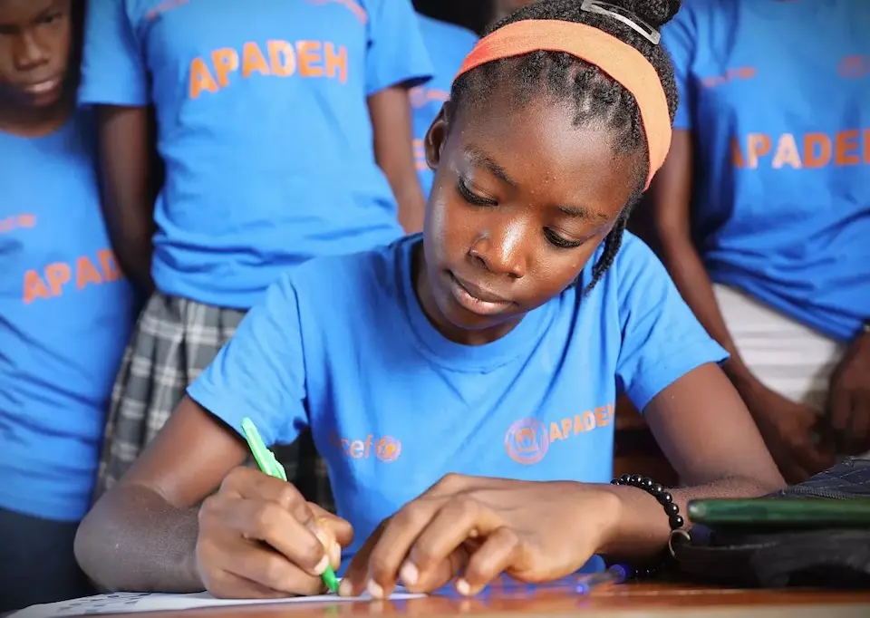 A girl concentrates during a cutting exercise in a UNICEF-supported screen-printing workshop in Haiti..