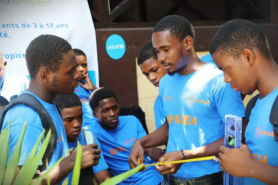 Young people listen carefully to their instructor during a UNICEF-supported job skills program in Haiti.