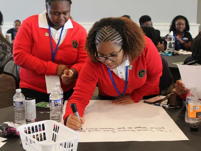 Two students writing an impact statement