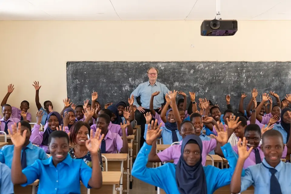 Students wave and MS NOW's Lawrence O'Donnell stands in the back of a classroom in Malawi.