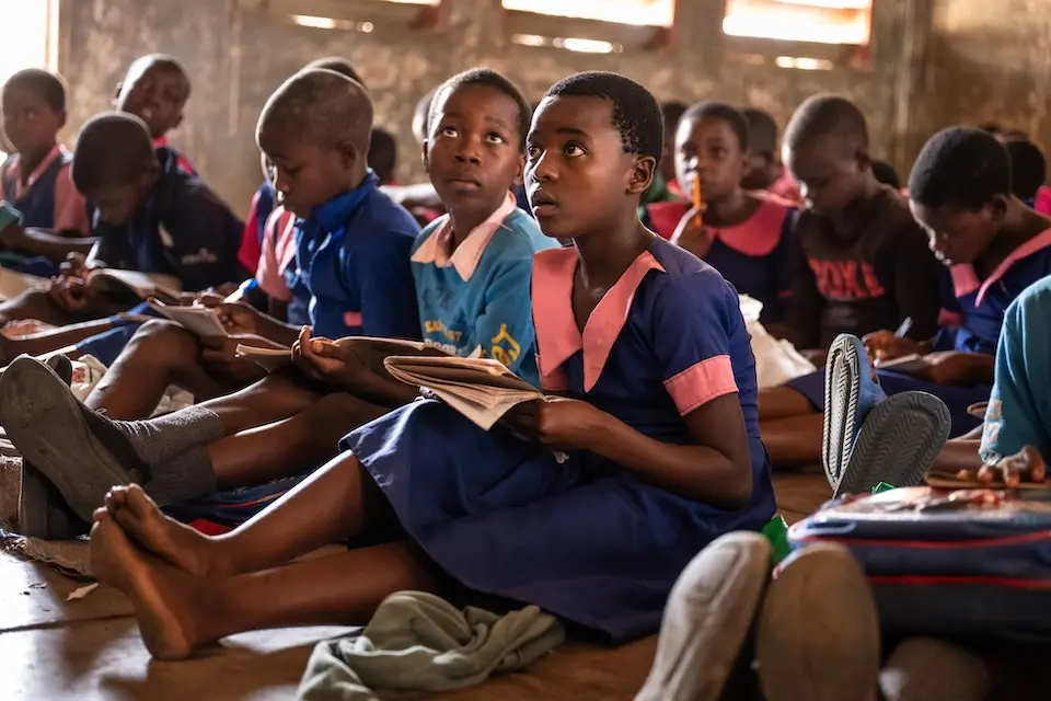 Students sit on the floor in a crowded classroom in Malawi.