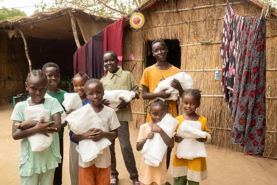Children hold new bed nets outside their home in Arabee neighborhood in Damazine, Blue Nile state, Sudan.