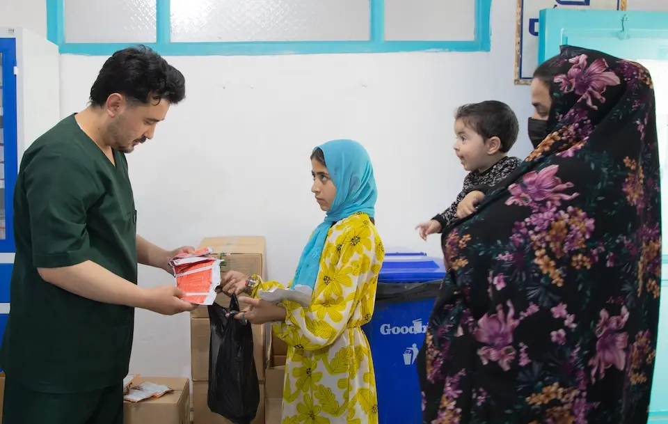 A UNICEF-supported frontline worker hands packets of ready-to-use therapeutic food to the sister of Haneya, an 11-month-old baby suffering from acute malnutrition, at a hospital in Guzarah district, Herat province, Afghanistan.