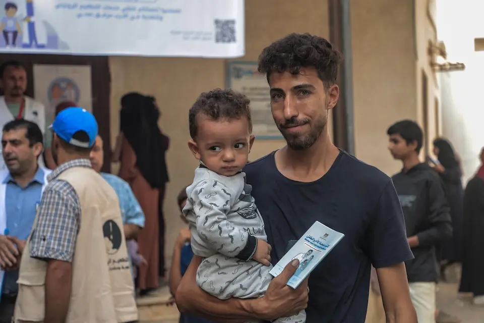 In Gaza on Nov. 11, 2025, a father holds his 1-year-old son, who has just been vaccinated during a UNICEF catch-up campaign. 