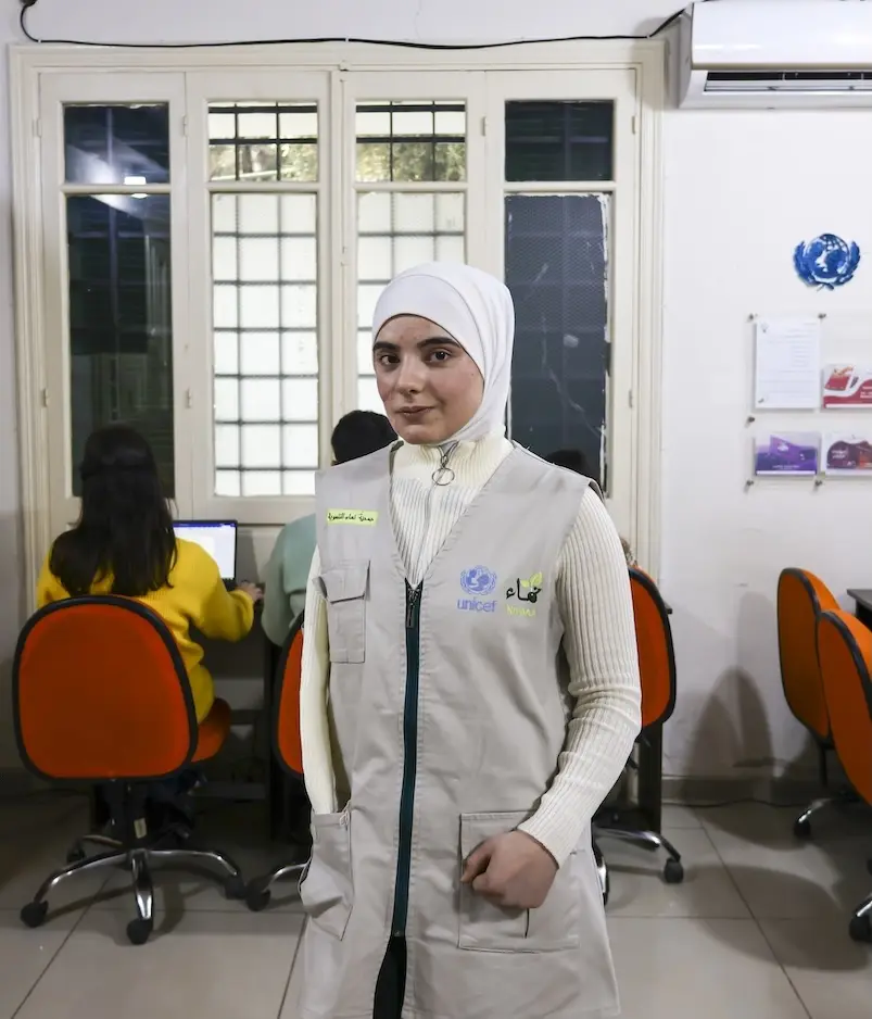 Cidra, 16, stands by computer terminals inside a UNICEF-supported support center for adolescents in Aleppo, Syria.