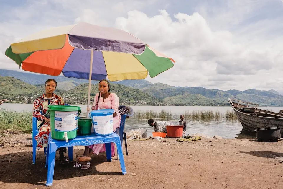 UNICEF-supported community outreach workers manage a water chlorination point by a lake in Minova, South Kivu province, DR Congo.