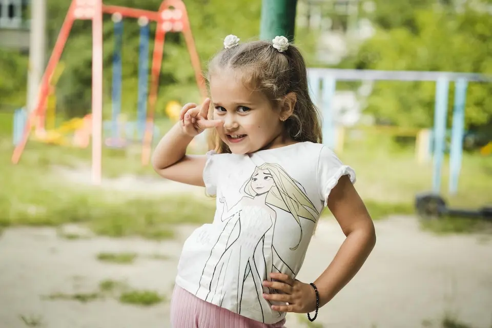 A 4-year-old girl poses for the camera at a playground in Sumy, Ukraine, a frontline city where shelling and power cuts are a fact of life. 