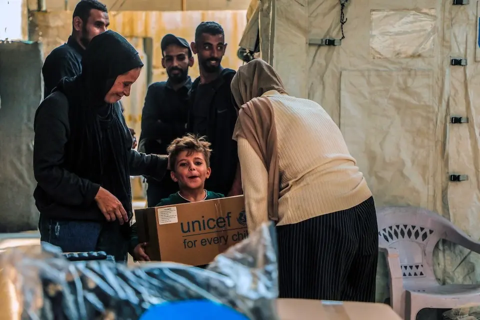 On Nov. 11, 2025, a boy holds a box of winter clothing distributed by UNICEF in the Gaza Strip. 