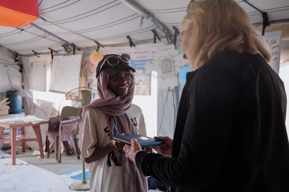 UNICEF Executive Director Catherine Russell interacts with a young girl inside a child-friendly space at a displacement camp in Port Sudan.