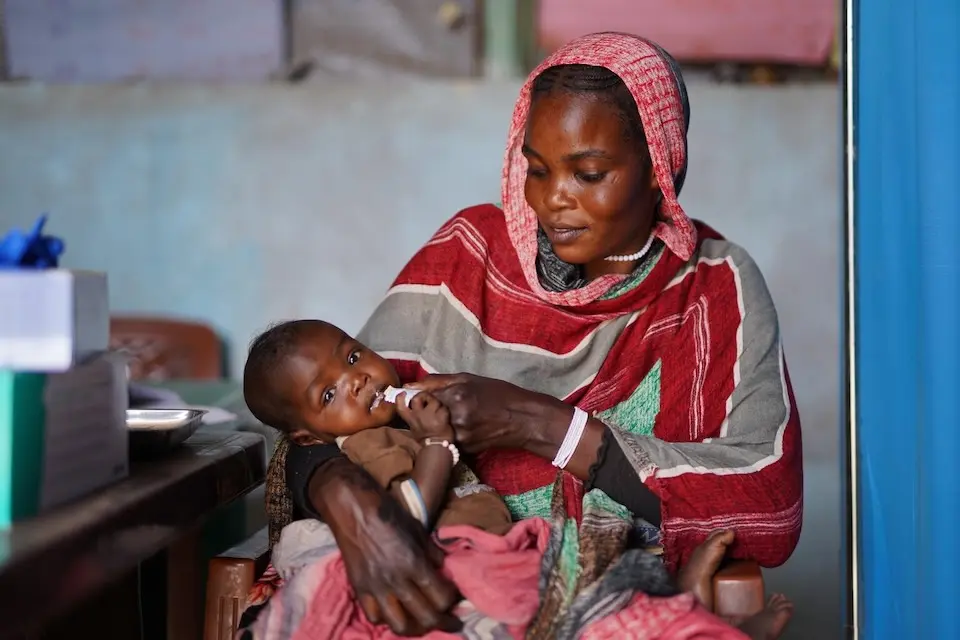 Halimah feeds her 7 months old daughter Asyaa with a nutrition supplement at a UNICEF-supported nutrition centre in Tawila, North Darfur. (© UNICEF /  Mohammed Jamal /  UNI914634)