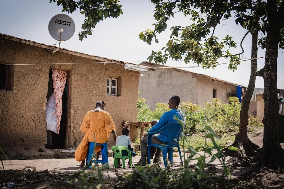 A 6-year-old survivor of sexual violence sits with her parents in front of in front of their house in Bunia, Ituri Province, DR Congo.