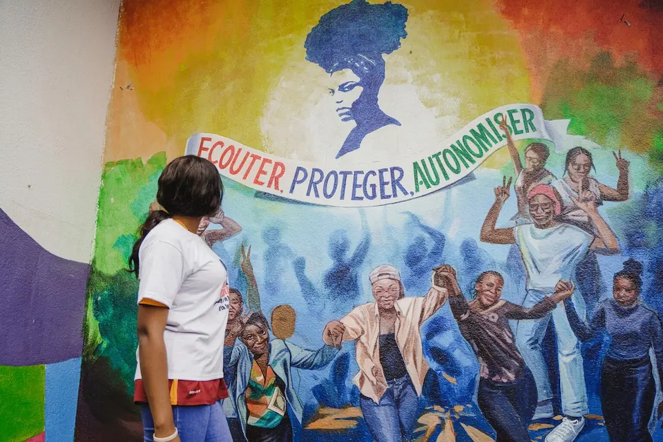 An 18-year-old survivor of sexual violence looks at a mural at a UNICEF-supported Toyokana safe space in Kalamu, Kinshasa, DR Congo.