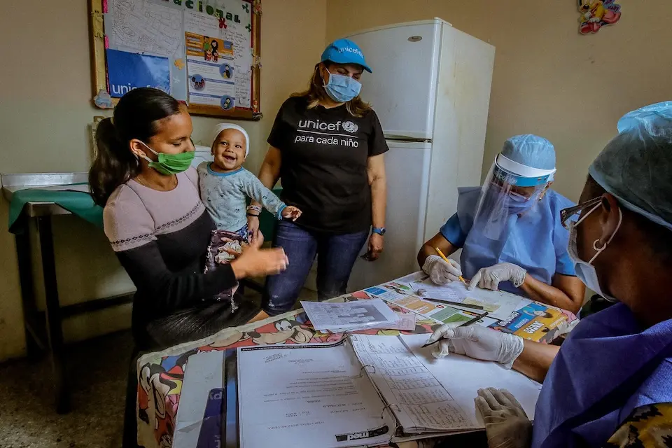 A UNICEF health officers visits a UNICEF-supported health center in Venezuela, assisting a family with their health care