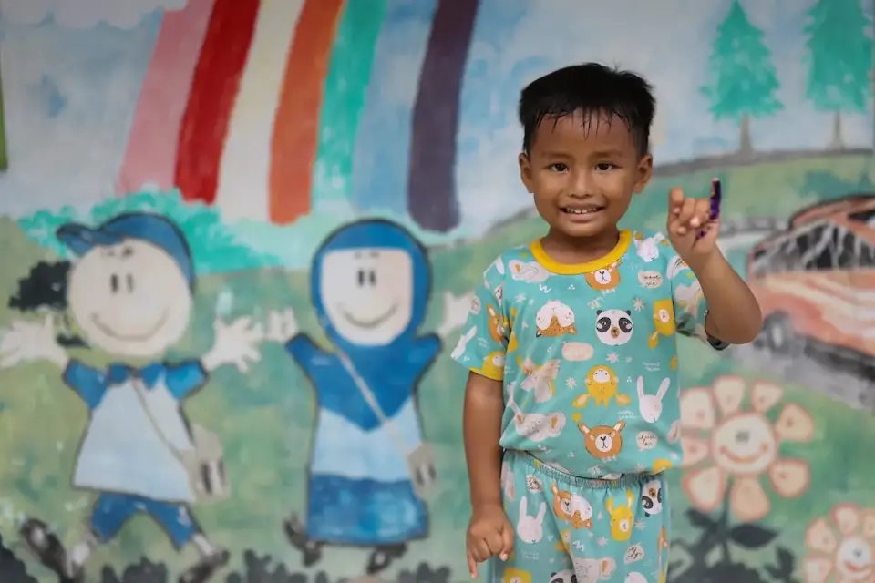 A boy holds up his ink-marked finger after his polio vaccination in Banjardawa Village, Indonesia.