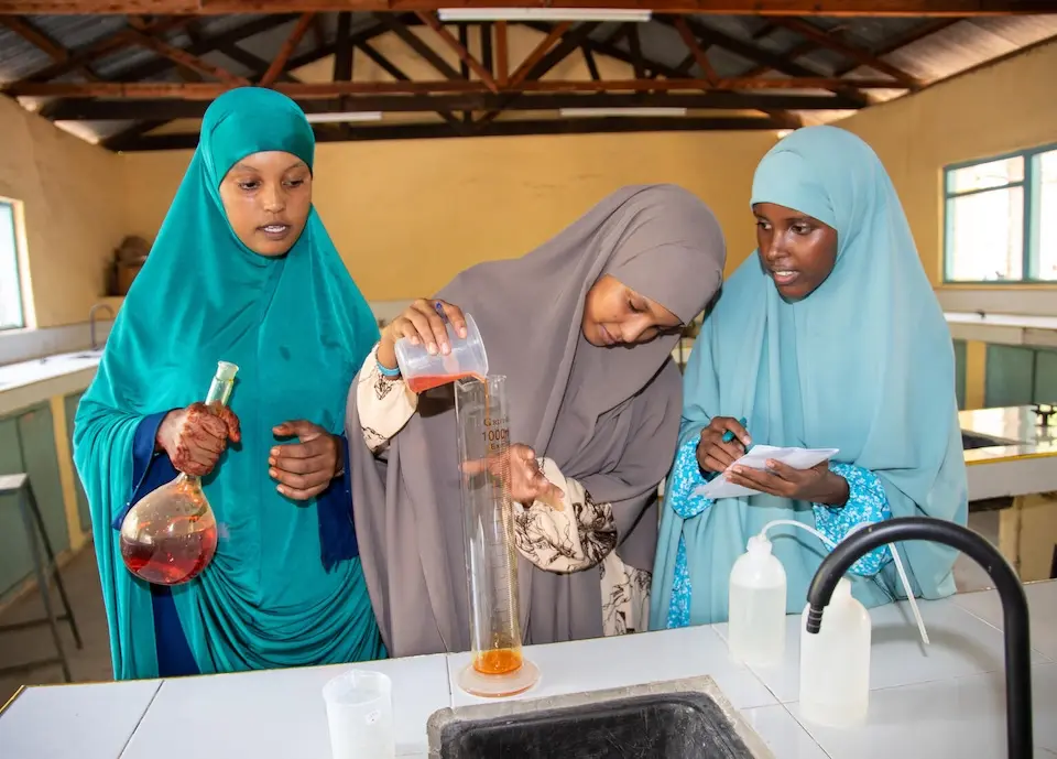 Three girls in Kenya participate in a UNICEF-supported program to get more girls interested in science fields. 