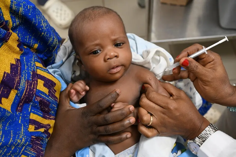 A mother holds her baby for a routine vaccination at UNICEF-supported CHR Hospital in Man, western Côte d'Ivoire, in 2025.