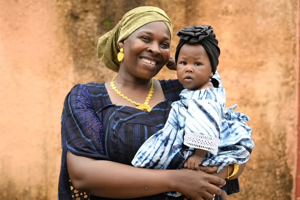 A 41-year-old mother holds her youngest child in Dixinn, a suburb of Conakry, the capital of Guinea.