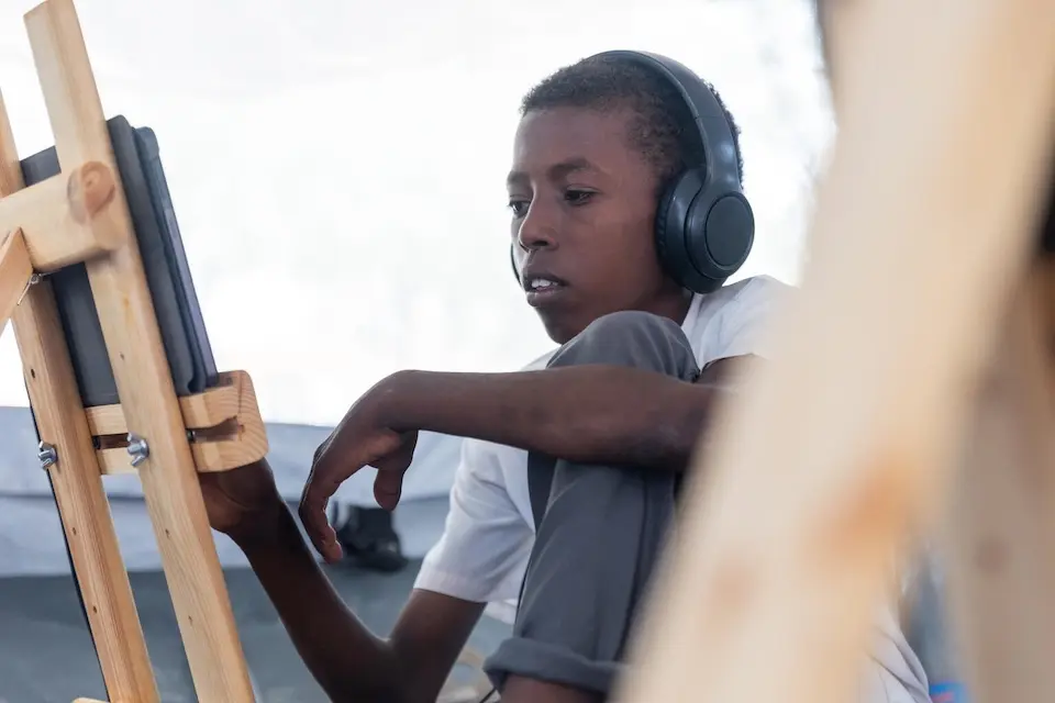 An 11-year-old wearing headphones looks at a screen on an easel during a UNICEF-supported digital learning session in Khartoum, Sudan on Oct. 16, 2025.