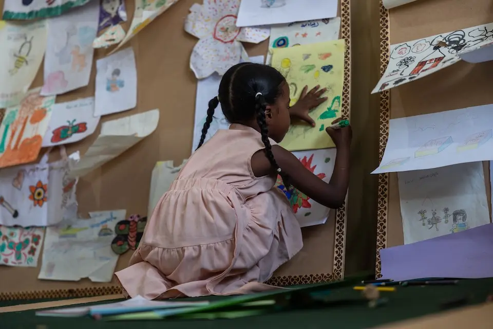A 5-year-old adds detail to her drawing at a UNICEF child-friendly space in Khartoum state, Sudan.