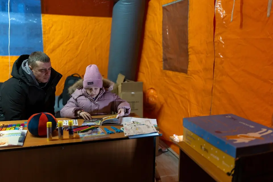 Two family members huddle inside a UNICEF-supported mobile support space in Kyiv, Ukraine.