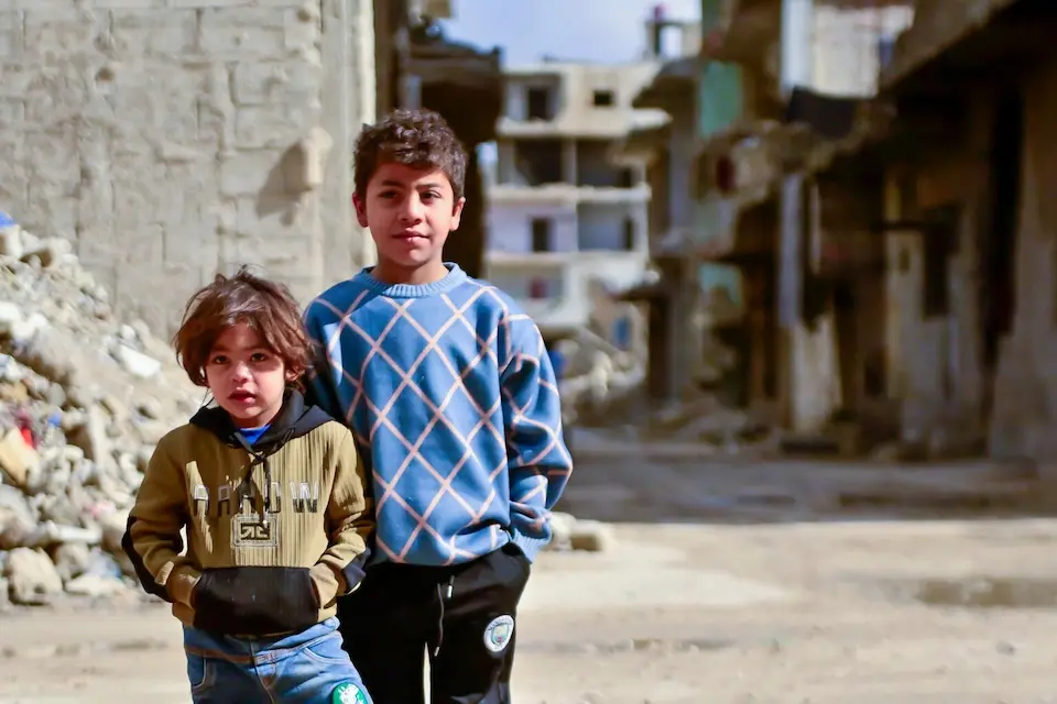 Children stand near damaged buildings in Tadamon, Damascus, Syria on Jan. 14, 2025.