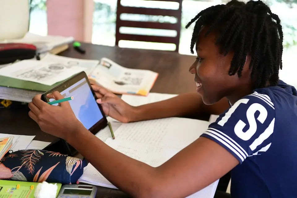 A girl uses a computer tablet to study at home in Abidjan, Côte d'Ivoire.