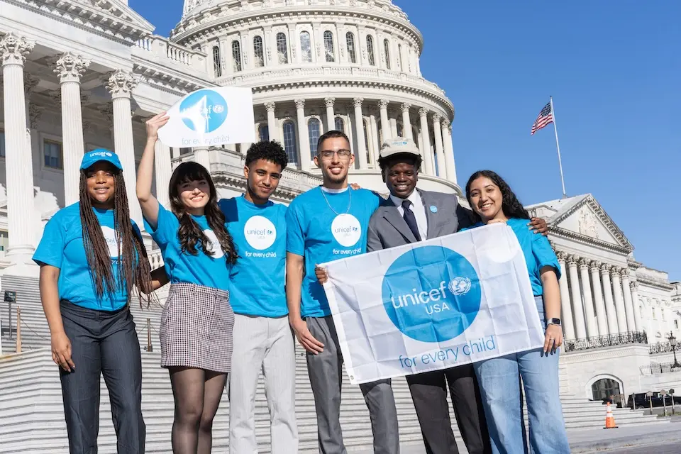Members of UNICEF USA's National Youth Council hold a banner outside the U.S. Capitol Building.
