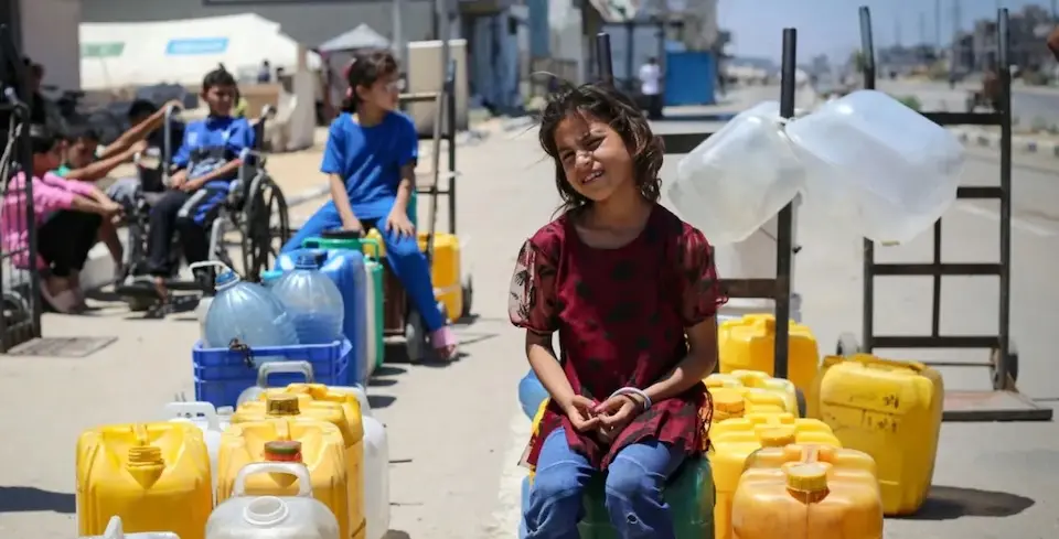 A 9-year-old girl at the Al- Bureij camp in Gaza waits her turn to fill a jug with safe water.