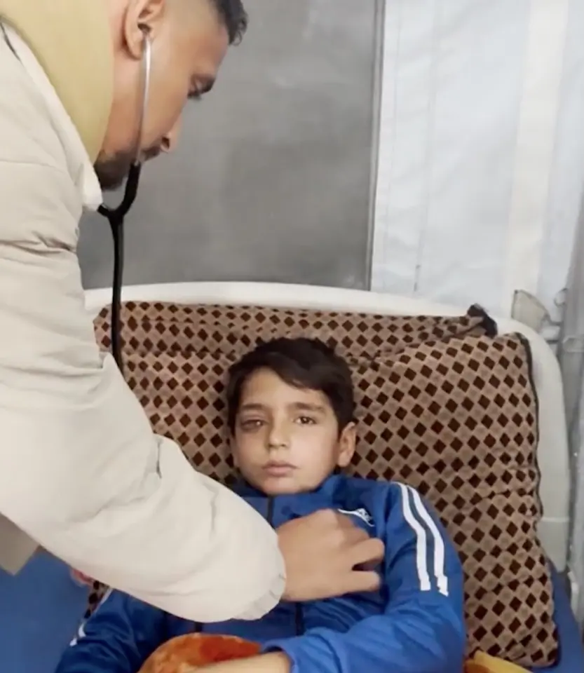 In Gaza, a doctor examines 9-year-old Abid, who suffered a severe eye injury when hit with shrapnel.